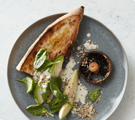 Avocado and tahini dressing on toasted sour dough bread